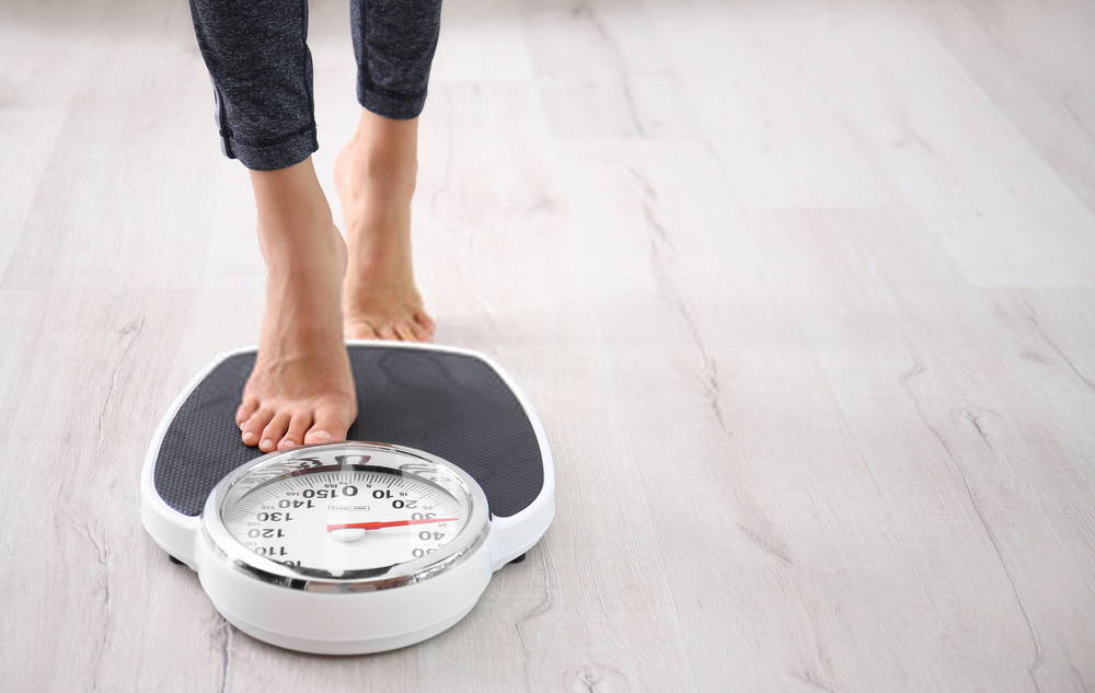 woman stepping onto bathroom scale