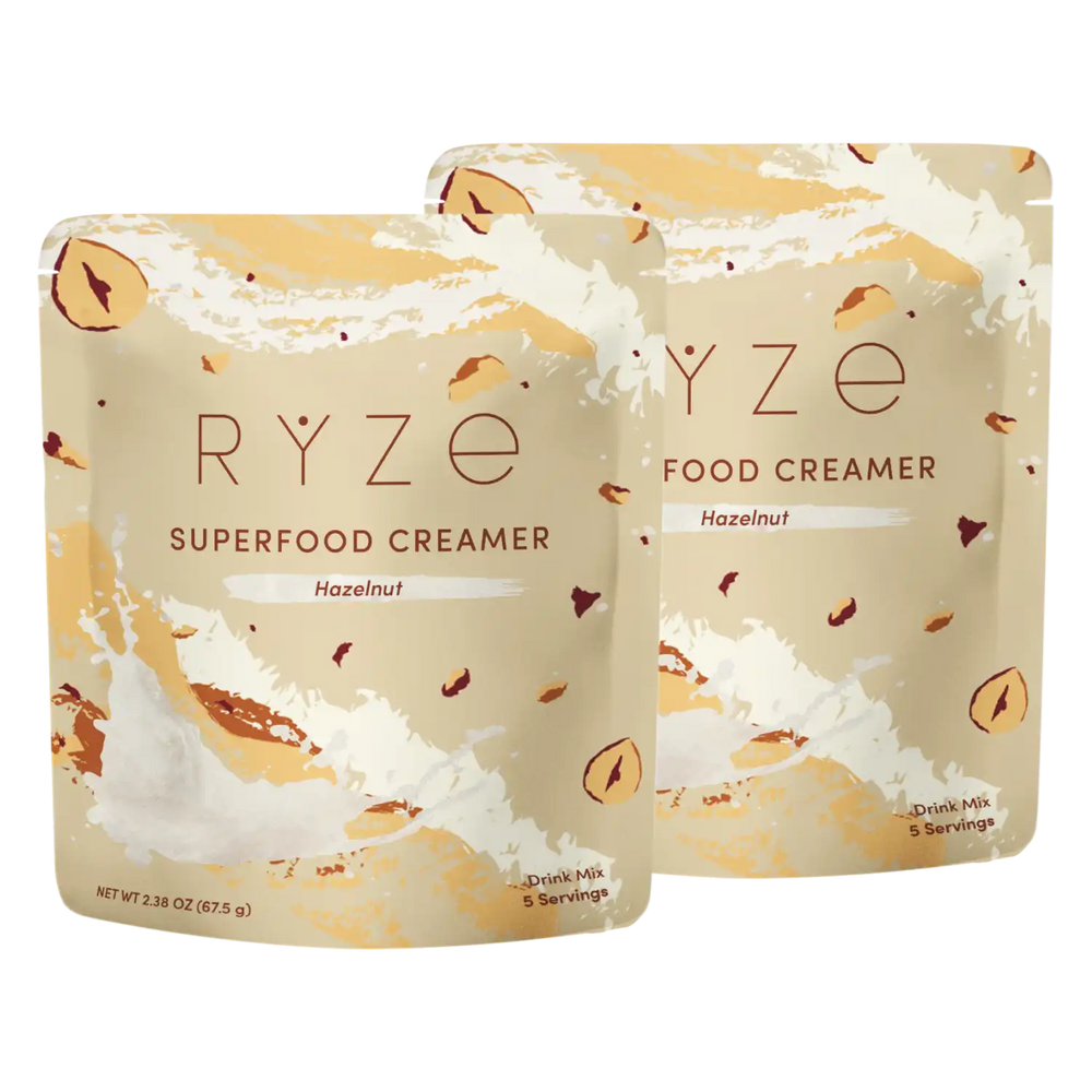 Two stand-up pouches of RYZE Food Creamer Superfood Creamer in Hazelnut flavor, shown overlapping on a plain white background.