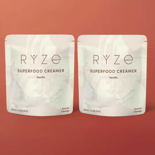 Two packages of RYZé Superfood Creamer on a red background