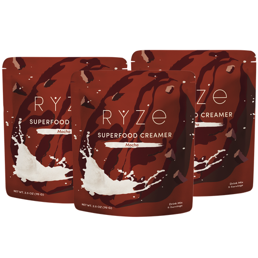 Three stand-up pouches of RYZE Superfood Creamer in Mocha flavor, arranged in a fan-like composition on a plain white background.