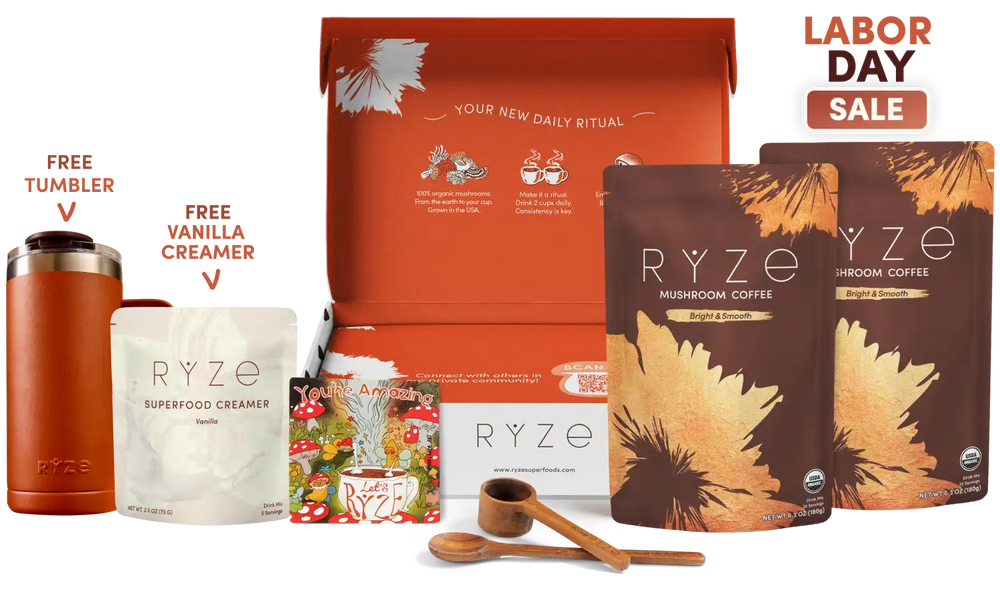 A RYZE Labor Day gift set displayed on a white background, featuring an orange gift box, two coffee pouches, a creamer pouch, a free tumbler, a free vanilla creamer pouch, wooden measuring spoons, and a 'Labor Day Sale' badge.