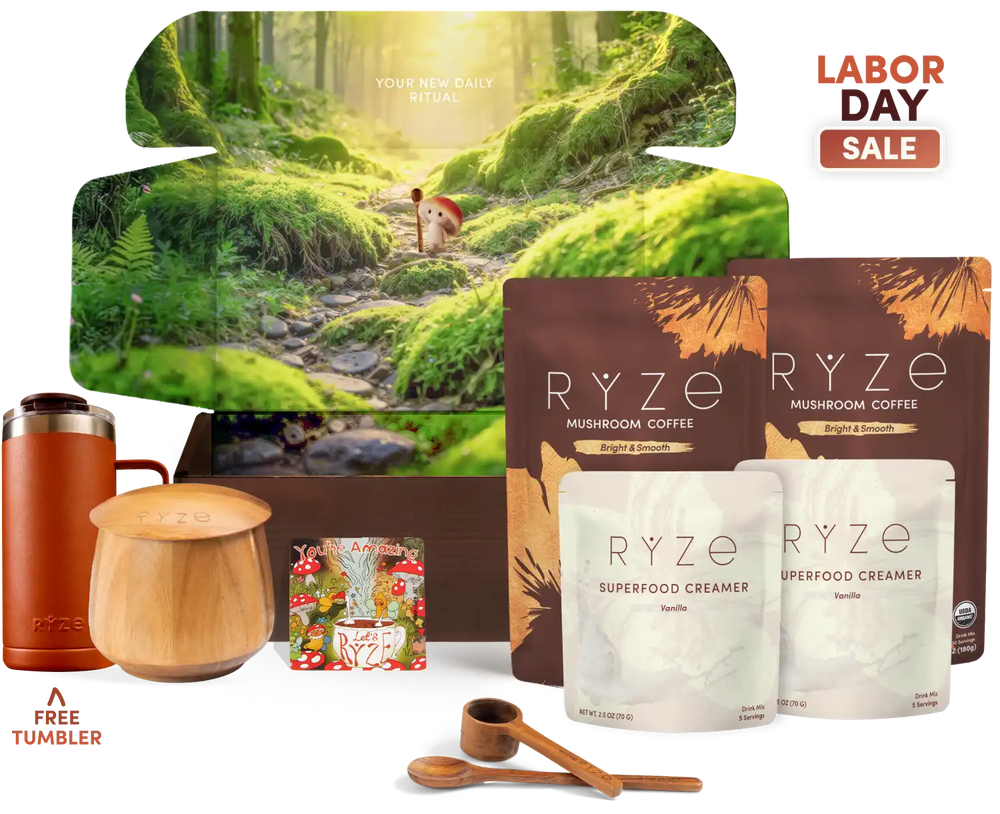 Labor Day gift set featuring RYZE Mushroom Coffee and Superfood Creamer pouches, a wooden jar, a wooden lid, a copper tumbler, and a free tumbler, arranged in front of a large forest-themed box on a white background.