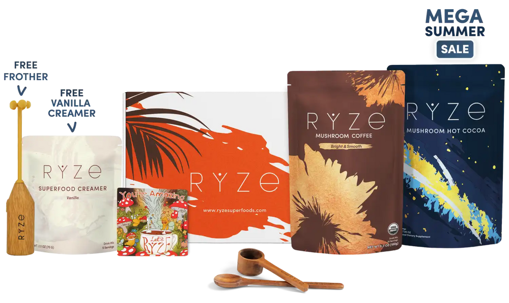 A RYZE summer gift set featuring mushroom coffee and hot cocoa pouches, a vanilla creamer pouch, a wooden frother, a illustrated magnet and two wooden spoons, arranged on a white background with 'MEGA SUMMER SALE' text in the top right.