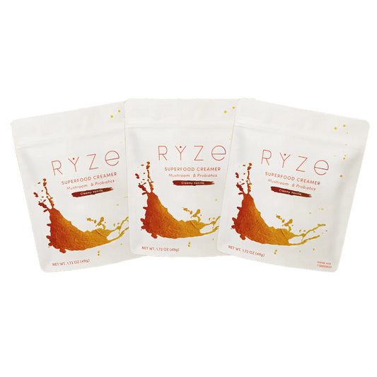 Three RYZE Superfoods Creamy Vanilla superfood creamer pouches with mushroom and probiotic blend, white packaging with orange splash design, arranged in a fanned row