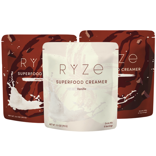 Three stand-up pouches of RYZE Superfood Creamer, with the center Vanilla pouch in front and 2 pouches of the Mocha flavor visible behind it on a white background.