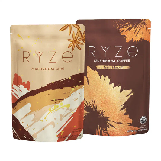 Two RYZE Mushroom Coffee pouches standing side by side on a white background. The left pouch is labeled Mushroom Chai and has a beige, brown, orange, and white abstract design with Mushroom Coffee in brown on the right.