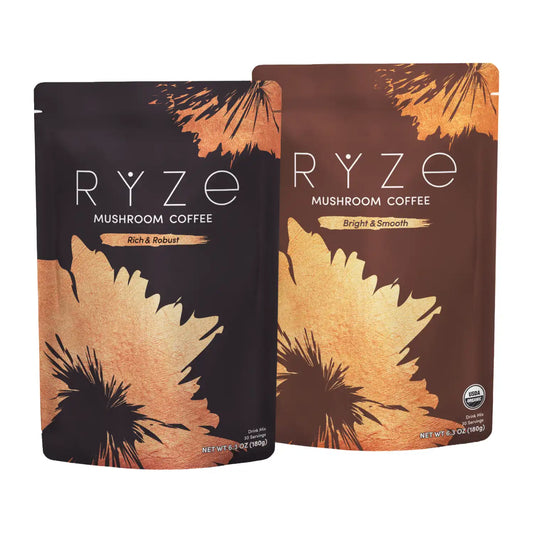 Two stand-up pouches of RYZE Mushroom Coffee on a plain white background. The left pouch is dark brown with black and gold leaf-like graphics and reads 'RYZE MUSHROOM COFFEE Rich & Robust.