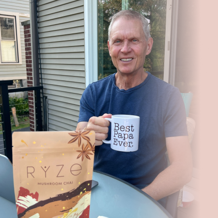 Person holding a Ryze Mushroom Chai package outdoors.