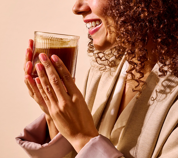 Glass of iced coffee with a package of mushroom chicory and a plant on a wooden tray.